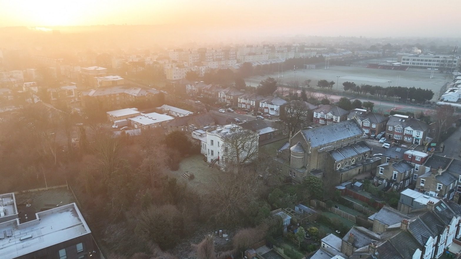 Aerial view of the church and Highcombe House at sunrise